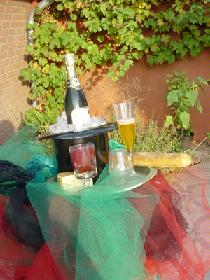 Kopfbedeckung mit Champangner im Zylinder mit Eiswürfel, Bordeauxweinglas, Congnagglas, Champangnerglas, Baguett und Käse.